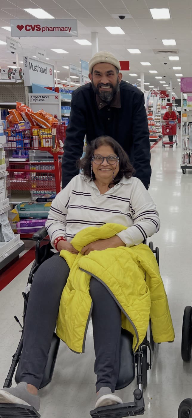 My mom in her wheelchair with me behind her, out shopping